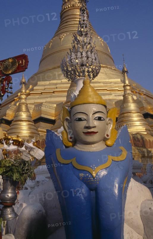 MYANMAR,  , Yangon, Schwedagon Pagoda temple detail with statue in the the foreground