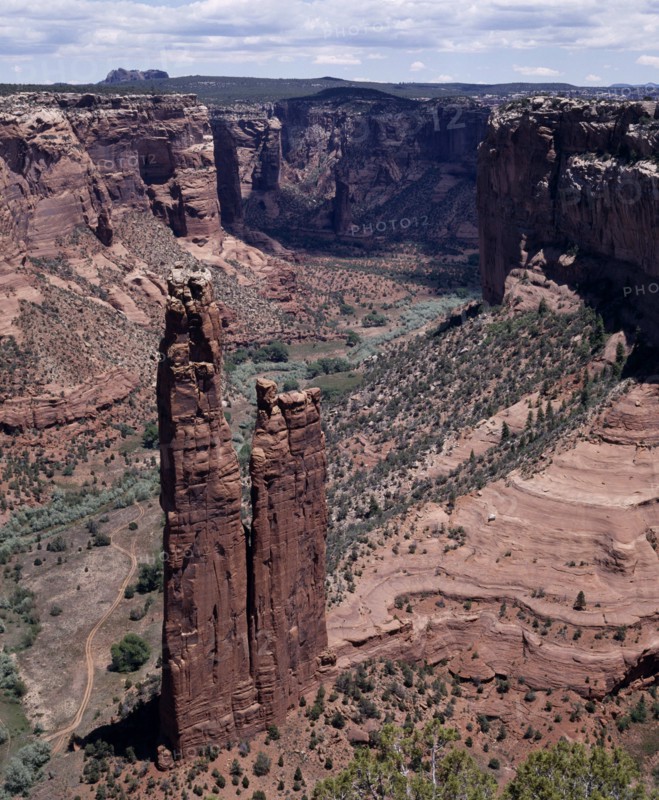 USA, Arizona, Canyon de Chelly, View looking down to Spider Rock with canyon beyond and scree slopes. A path cuts through canyon floor.