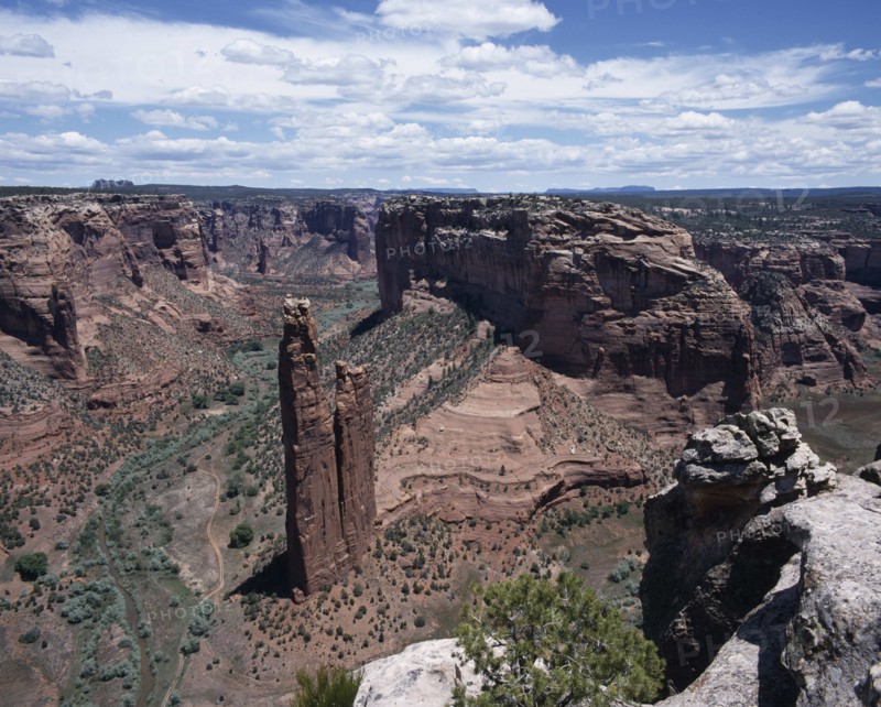 USA, Arizona, Canyon de Chelly, View looking down to Spider Rock with canyon beyond and scree slopes. A path cuts through canyon floor.