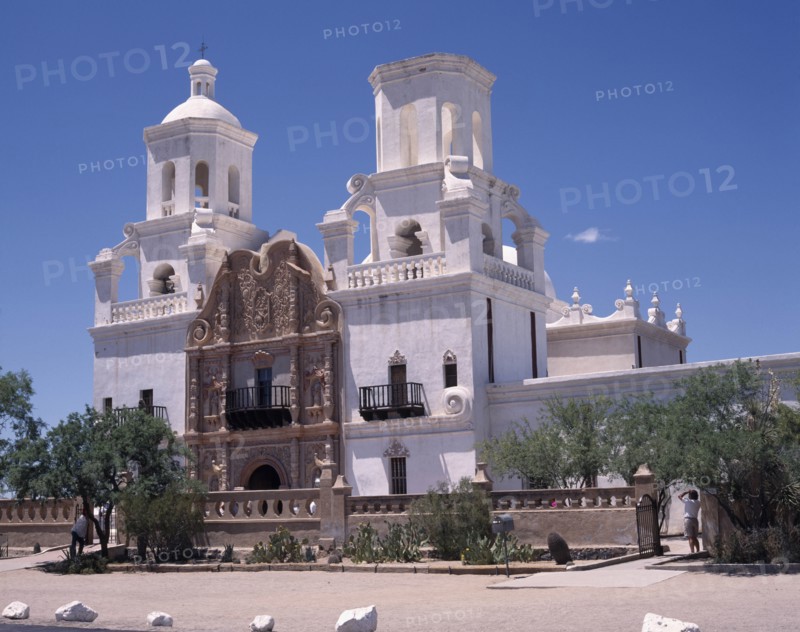 USA, Arizona, Tuscon, San Xavier del Bac Mission. White-washed building with  towers an ornate entrance and balconies