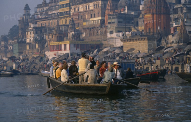 INDIA, Uttar Pradesh, Varanasi, Tourists in boat being rowed passed the ghats on the River Ganges.