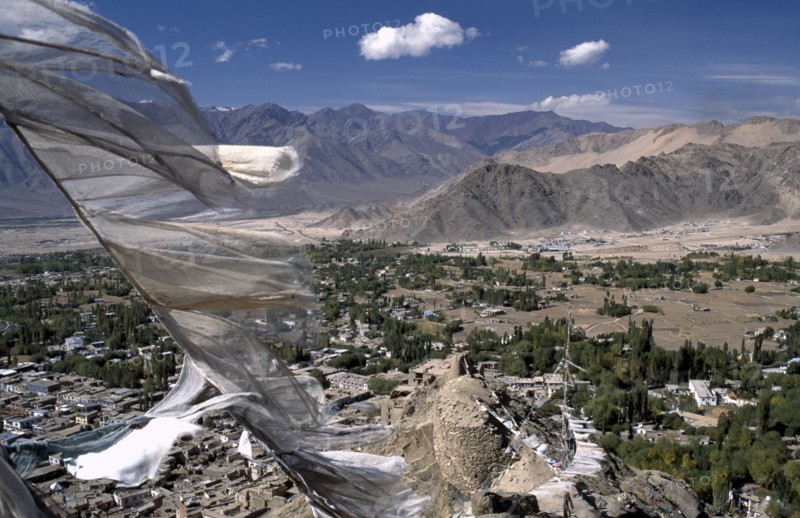INDIA, Ladakh, Leh Valley , Prayer flags blowing in the wind above village and mountainous terrain