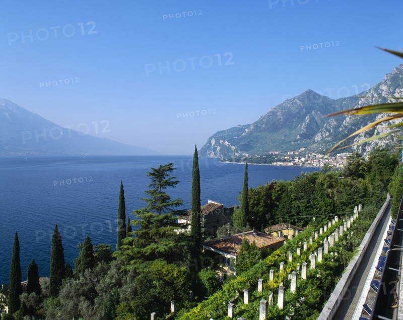 ITALY, Lake Garda,  Limone, "View over roof tops to lake, town to far right, distant hills, blue sky. "
