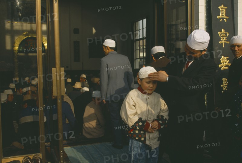 CHINA, Gansu Province, Lanzhou, Family outside mosque.