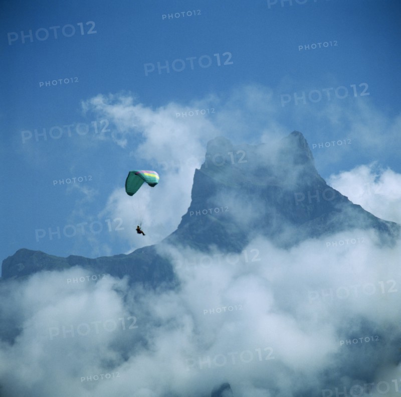 SWITZERLAND, Engelberg, View of mountain top through mist with paraglider