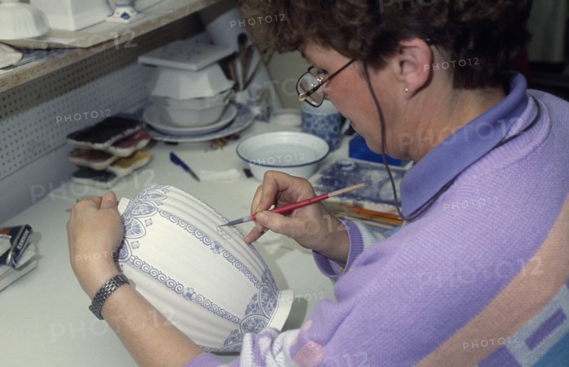 HOLLAND, Industry, Delftware, Female worker painting design onto delftware vase.
