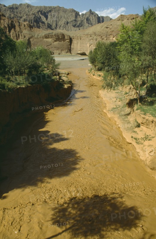 CHINA, Yellow River , View over rapid flowing silt laden water toward main river