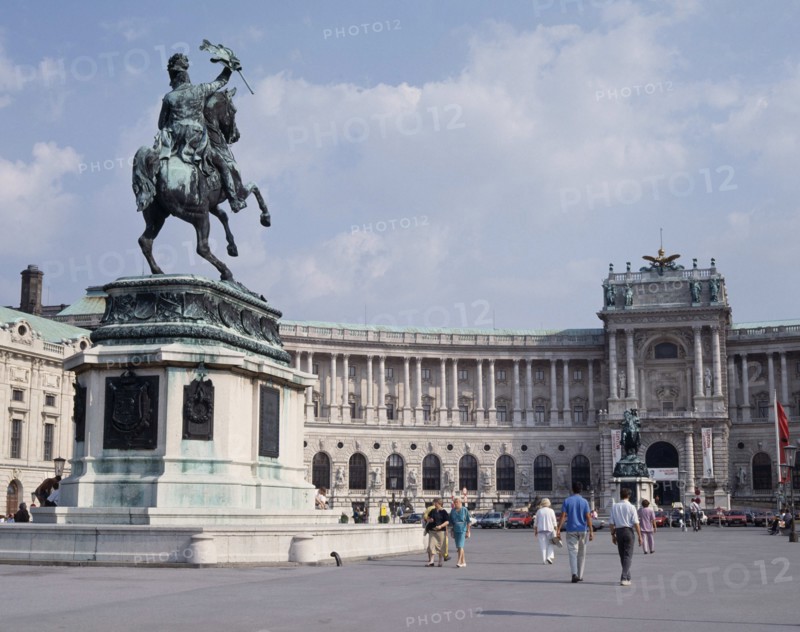 AUSTRIA, Lower Austria, Vienna, Hofburg Palace. Equestrian statue on plinth standing in courtyard outside semi circular facade with passing people.