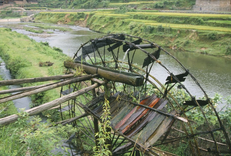 CHINA, Guangxi, Bamboo water wheel on the edge of a river.