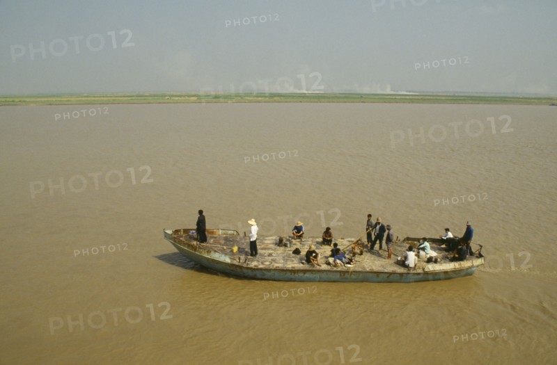 CHINA, Henan, Near Zengzhou, Rusty passenger ferry sailing along the Yellow River