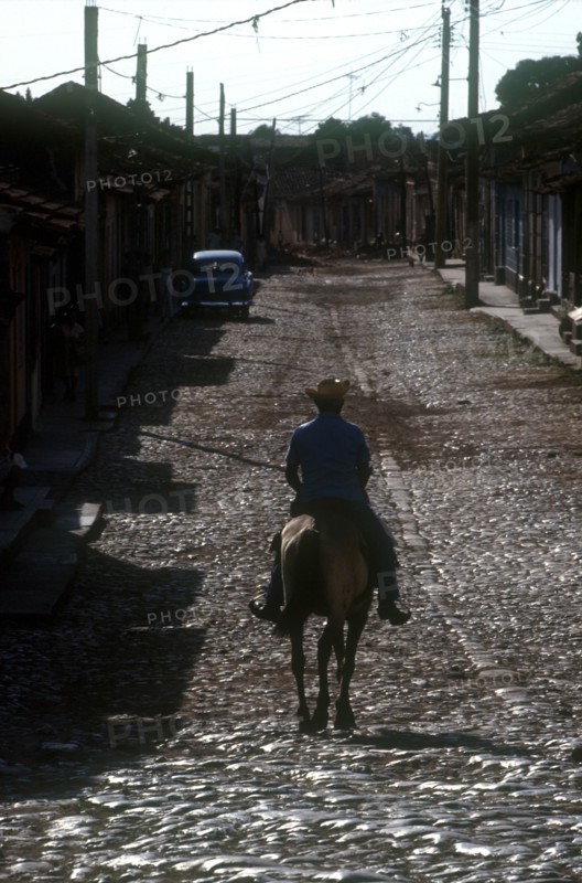 CUBA, Sancti Spiritus, Trinidad, Man riding horse on cobbled street