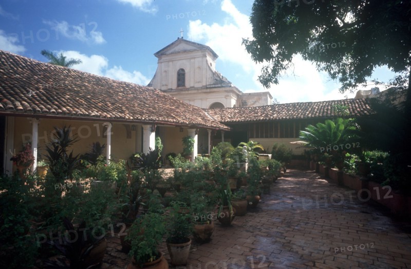 CUBA, Sancti Spiritus, Trinidad, View over plant lined courtyard toward church building