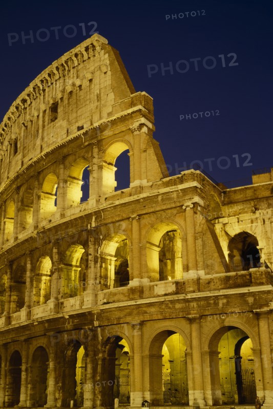 ITALY, LAZIO ,  ROME, The Colosseum exterior view at night of floodlit walls set against dark sky.
