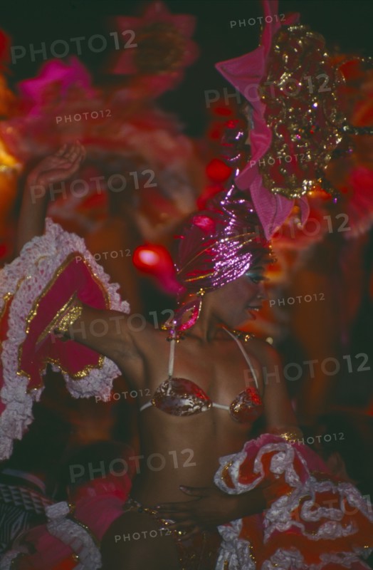 CUBA, Havana Province, Havana, Tropicana Club female dancer in pink costume in front of other dancers