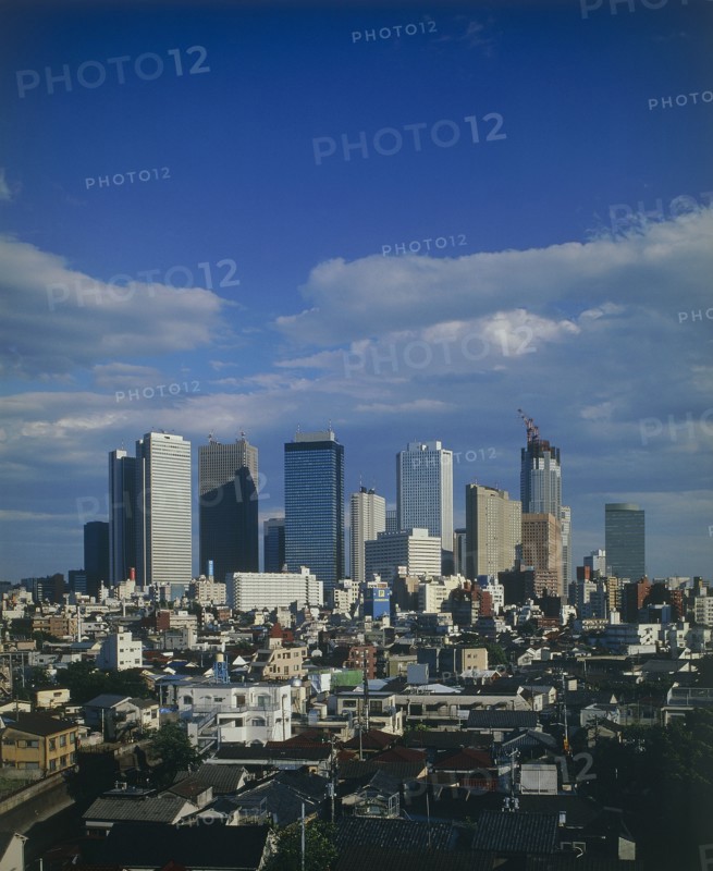 JAPAN, Honshu, Tokyo, View over city rooftops with high-rise buildings and skyscrapers in the background