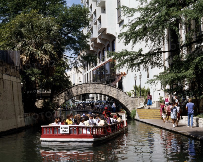 USA, Texas, San Antonio, Pleasure boat passing under a bridge over Paseo del Rio beside the River Walk