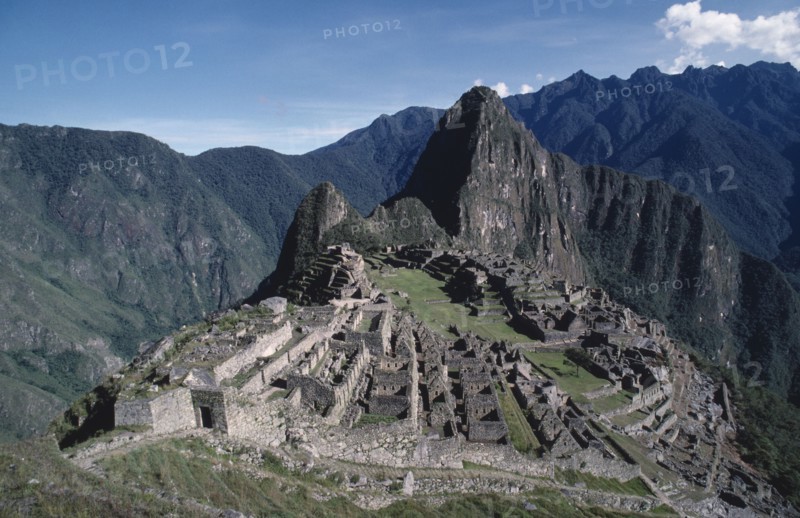 PERU, Cusco , Machu Picchu, View looking down on hilltop Inca city ruins surrounded by mountainous landscape