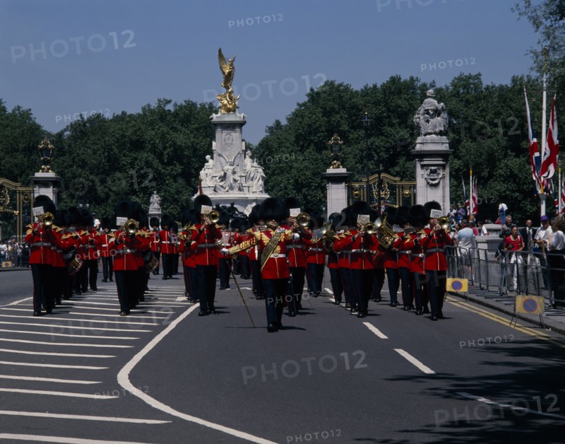 ENGLAND, London, Pageantry Marching guards band with The Victoria Memorial behind. Union Jack flags and tourists watching from pavement