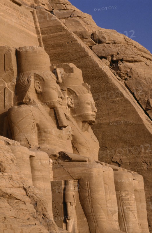 EGYPT, Abu Simbel, Two of the giant statues of Ramesses II at the entrance to the Great Temple