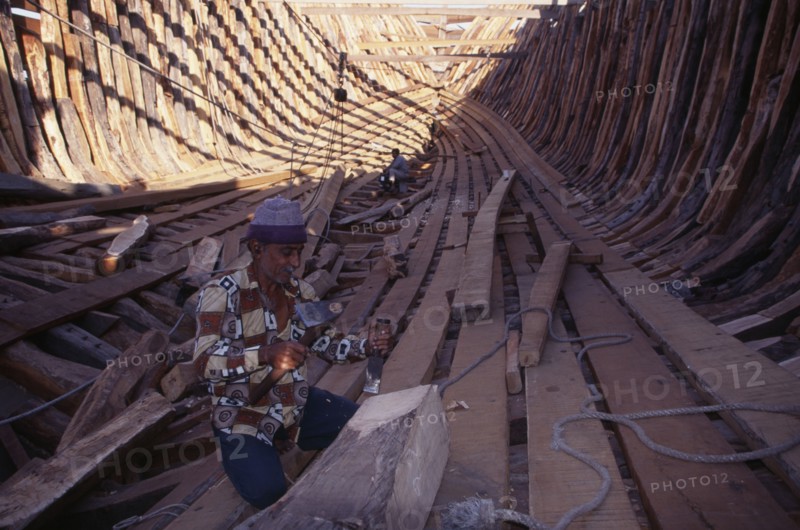INDIA, Gujarat, Veraval, Shipbuilding.  Men work on interior of boat.
