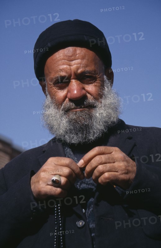 IRAN, Tabriz  , Portrait of an elderly man dressed in black with prayer beads