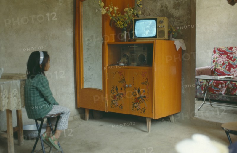 MEDIA, Television, Young girl sat on stool watching television