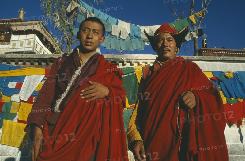 TIBET, Lhasa, Jokhang Temple, Two Buddhist monks in front of prayer flags