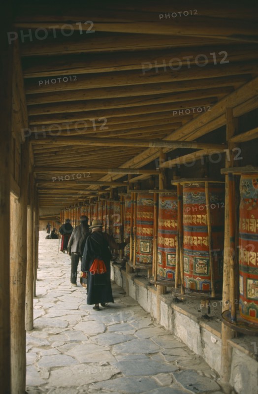 CHINA, Gansu Province, Labrang Monastery, Tibetan pilgrims turning prayer wheels.
