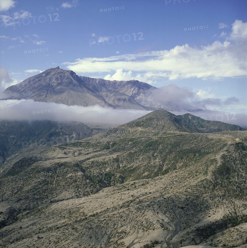 USA, Washington, Mount St Helens, The volcano shrouded in cloud after the eruption with the devastated landscape below