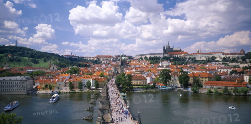CZECH REPUBLIC, Stredocesky, Prague, Charles Bridge. View over busy bridge and city rooftops beyond.