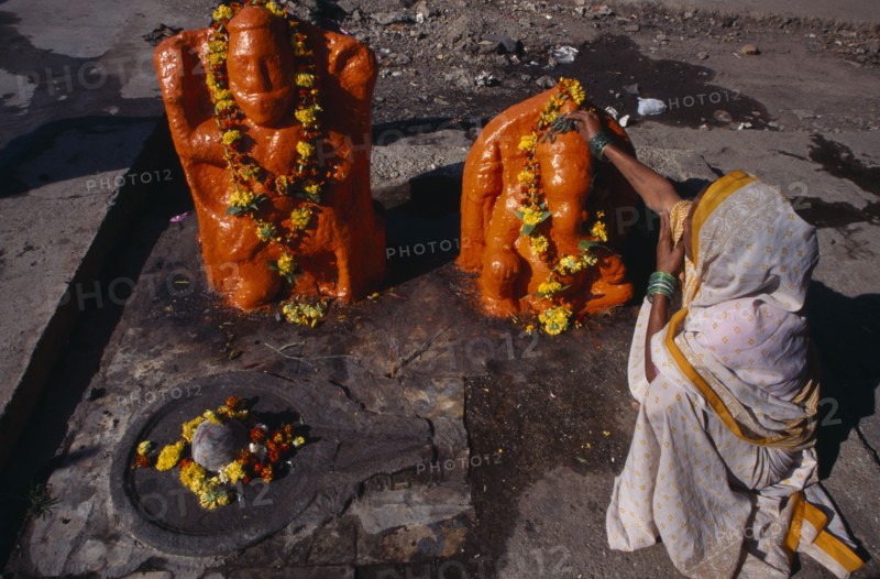 INDIA, Maharashtra, Nasik, Woman making votive offerings at Ganesh shrine