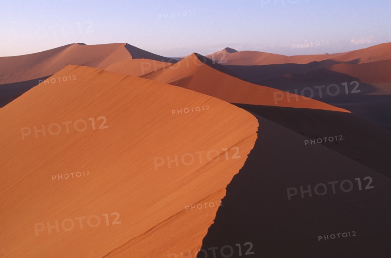 NAMIBIA, Namib Desert, Red sand dunes partially cast in shadow