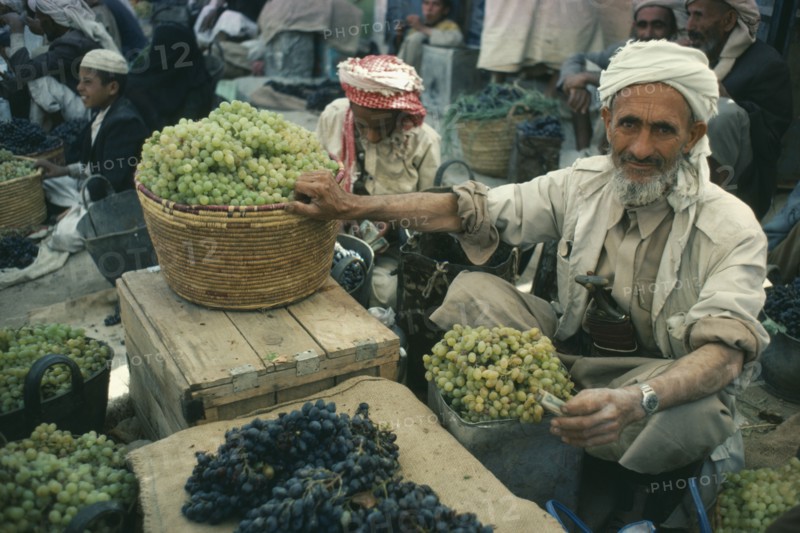 YEMEN, Saada, NOT IN LIBRARY Grape vendor in Souk holding green grapes