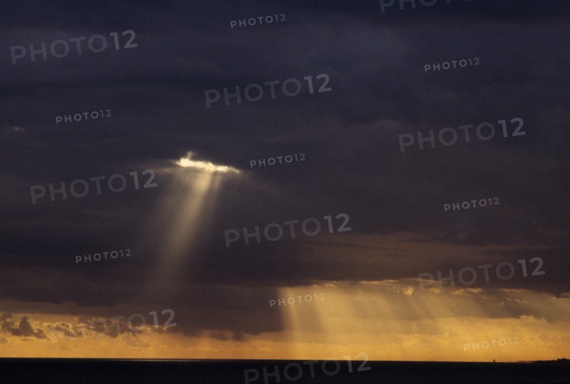 WEATHER, Climate, Clouds, Sun rays breaking through thick grey cloud.