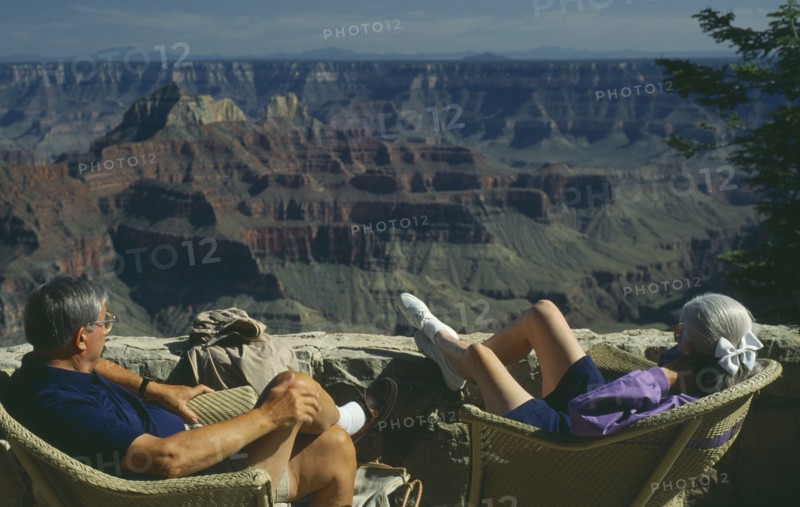 USA, Arizona, Grand Canyon, The North Rim with elderly couple seated
