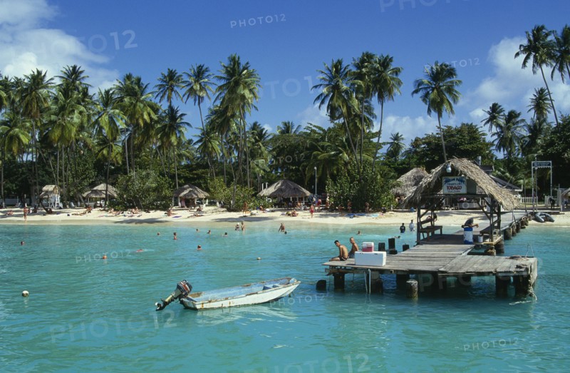 WEST INDIES, Tobago, Pigeon Point, Boat jetty and beach from the sea with tourists sunbathing and swimming