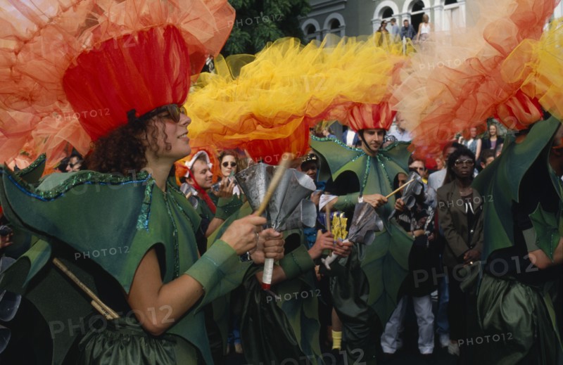 ENGLAND, London, Notting Hill Carnival dancers wearing flower costumes and playing hand held steel percussion instruments