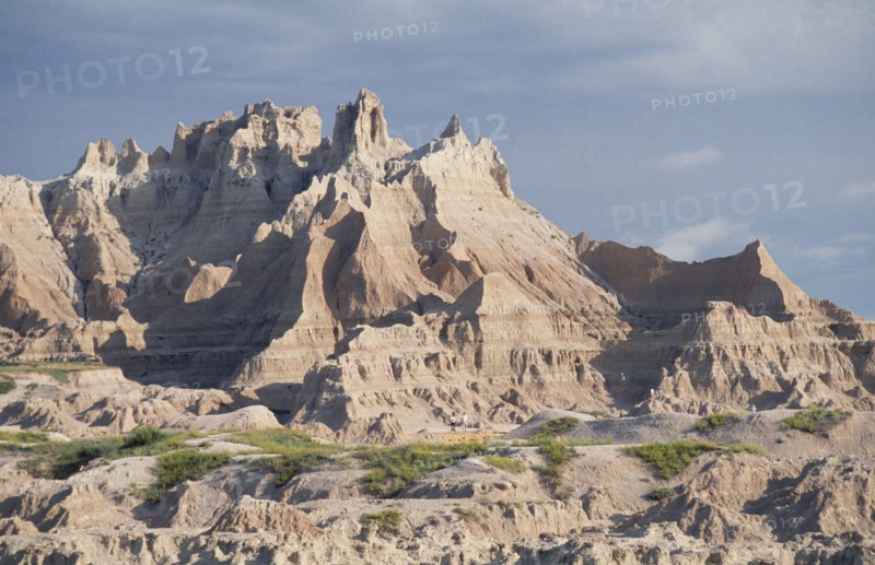 USA, South Dekota, Badlands National Park, Rocky peaks with people standing at the base
