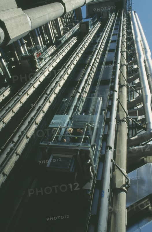 ENGLAND, London, View looking up at the lifts with pasengers on the exterior of the Lloyds building
