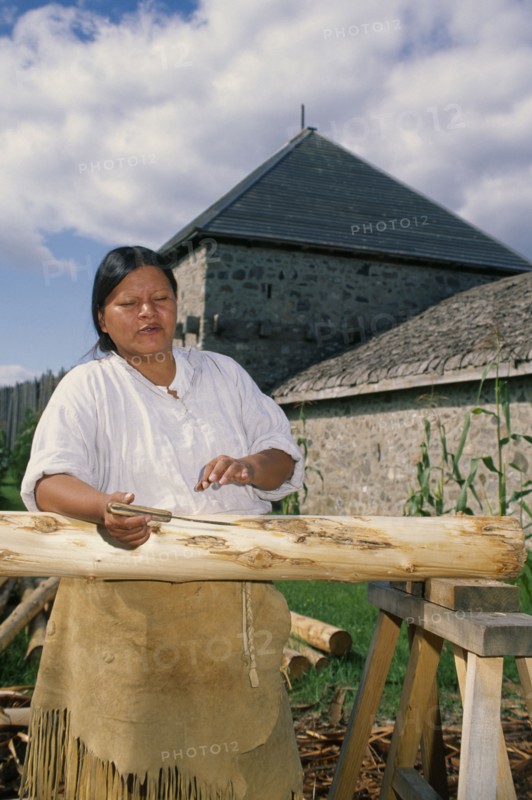 CANADA, Ontario, Sainte Marie, Ojibway Indian woman stripping the bark from trees