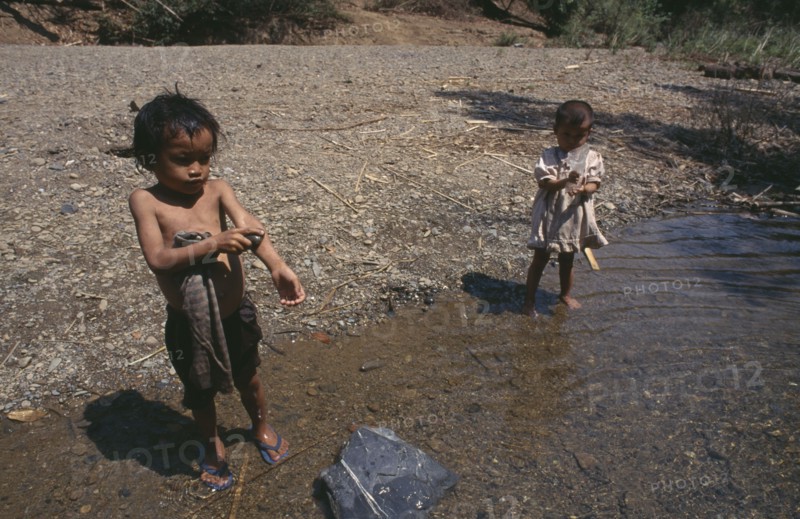THAILAND, North, Mae Sariang, Two young Karen refugee children washing at the waters edge