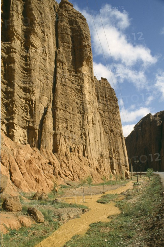 CHINA, Yellow River , Muddy water flowing alongside cliff edge and road