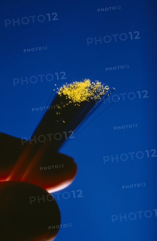 COMMUNICATIONS, Fibre Optics, Fibre optics cables with illuminated ends being held between a thumb and forefinger