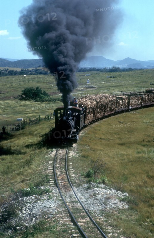 CUBA,  , Holguin, Train transporting sugar cane with plumes of black smoke pouring from the engine