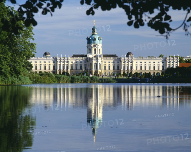 GERMANY, Berlin, Charlottenburg Palace and reflection in lake in the foreground.  Part framed by trees.