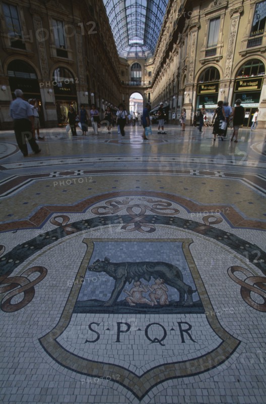 ITALY, Lombardy, Milan, Galleria Vittorio Emanuele II shopping arcade interior with glass domed roof and mosaic floor lined with designer shops.
