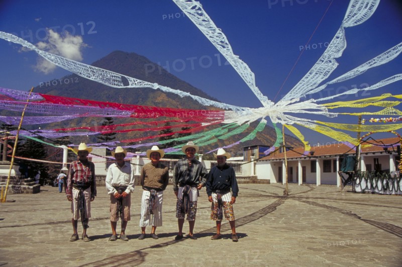 GUATEMALA, Santiago, Charismatic church festival with five local men standing under streamers
