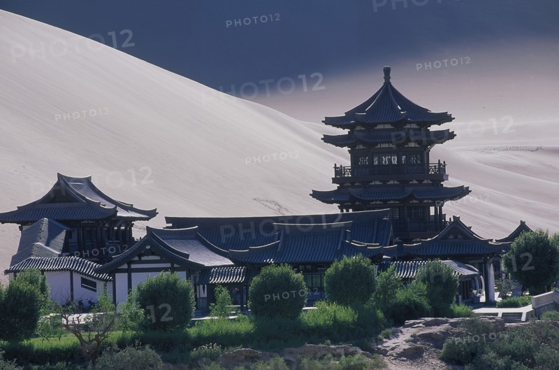 CHINA, Gansu, Dunhuang, Silk Route with a Buddhist Temple and sand dunes beyond
