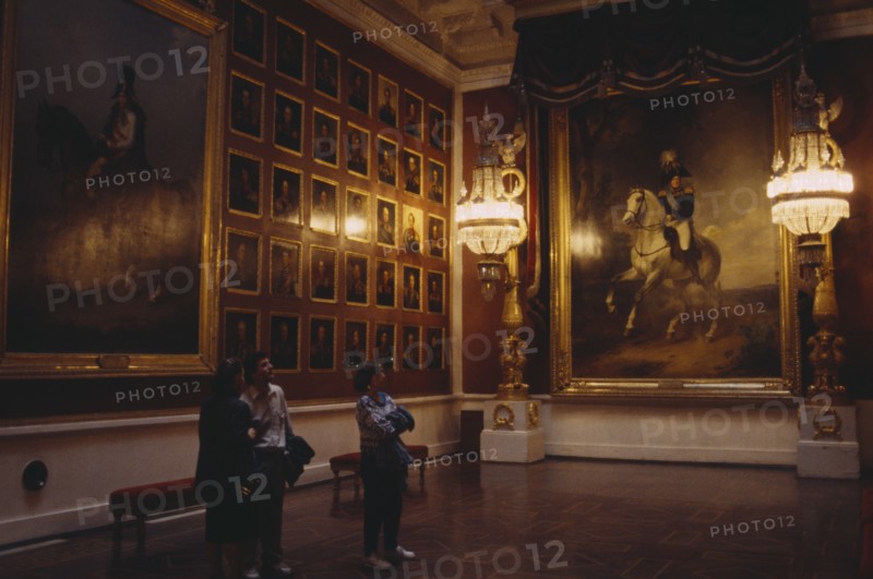 RUSSIA, St Petersburg, "The Hermitage Museum interior, room hung with portaits, three people look at paintings "