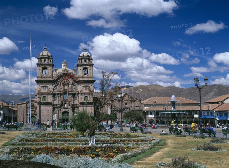 PERU, Cusco Department, Cusco, "Plaza de Armas.  View across colourful, formal garden towards La Compañía de Jesús.  "